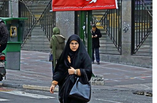 Eine iranische Frau  vor den Wahlplakaten in der Hauptstadt Teheran Foto: AP