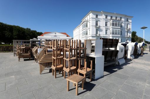 Auf der Uferpromenade vor dem Grand Hotel Heiligendamm stehen Tische und Stühle bereit, die im Außenbereich aufgestellt werden. Das Hotel an der Ostsee, das sich als Gastgeber des G8-Gipfels 2007 einen Namen gemacht hat, hat  am 10. Juni  nach monatelanger Corona-Pause wieder geöffnet . Foto: Bernd Wüstneck/dpa