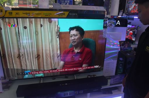 Ein Verkäufer eines Fernsehgeschäfts in Hanoi (Vietnam) schaut sich im August im vietnamesischen Staatsfernsehen das vermeintliche Geständnis des Geschäftsmanns Trinh Xuan Thanh an. Foto: AFP