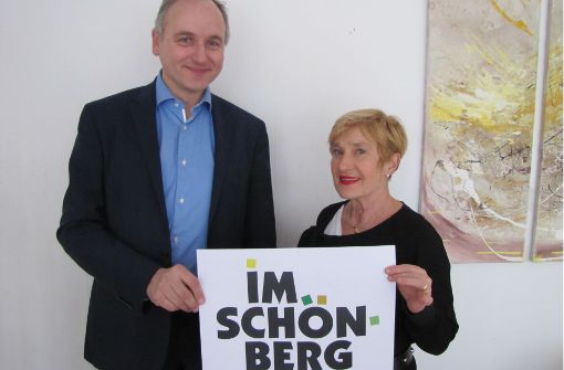 Veit Mathauer und Beate Mierendorf halten das neue Logo des Bürgervereins in die Kamera.   Der Schriftzug bildet die Umrisse des Stadtteils ab. Foto: Rehman