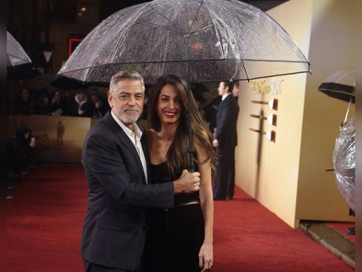 George und Amal Clooney mit Regenschirm in London. Foto: getty/Neil P. Mockford / Getty Images