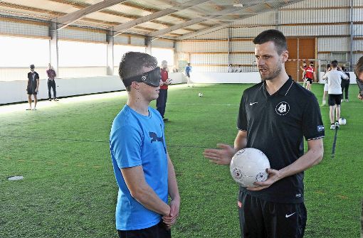 Alexander Fangmann aus dem Blindenfußball-Nationalteam erklärt Fabian Eberhardt (links) und Mick Heuschele die Übung. Foto: Werner Kuhnle