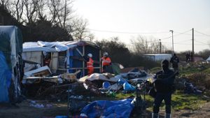 Unter Polizeischutz reißen Arbeiter Anfang März im Flüchtlingslager von Calais, dem „Dschungel von Calais“, Hütten ab. Foto: dpa