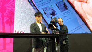 Der Gründer und Chef des US-Technologieunternehmens Brain Technologies, Jerry Yue, stellt bei der Mobile World Congress in Barcelona den Prototypen eines KI-Smartphones der Deutschen Telekom vor. Foto: Wolf von Dewitz/dpa