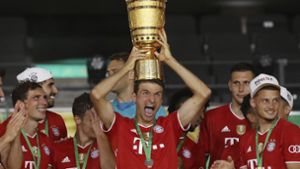 Gewohntes Bild: Thomas Müller und seine Bayern mit Pokal. Kommt im August ein weiterer dazu? Foto: AP/Alexander Hassenstein