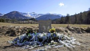Blumen und ein Gedenkstein erinnern an die Opfer des Absturzes im französischen Le Vernet. Foto: EFE FILE/dpa