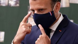 So geht Maske: Emmanuel Macron erklärt Schülern in Poissy, worauf es in der Coronakrise ankommt. Foto: AFP/IAN LANGSDON