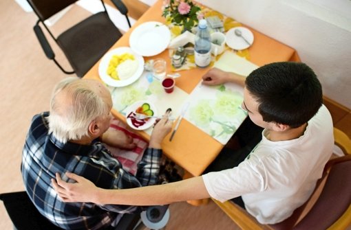 Ein Bufdi hilft einem alten Mann beim Essen in einem Heim der Arbeiterwohlfahrt Foto: dpa