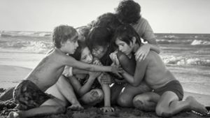 Das Kindermädchen Cleo (Yalitza Aparicio) in inniger und besorgter Umarmung mit Schützlingen am Strand. Foto: Netflix