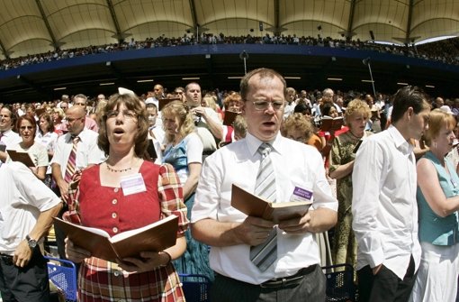 Teilnehmer eines Sonderkongresses der Zeugen Jehovas singen 2006 in der AOL Arena in Hamburg während einer Massentaufe. Foto: dpa