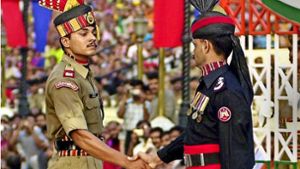 Ein pakistanischer (rechts) und ein indischer Grenzbeamter. Foto: EPA
