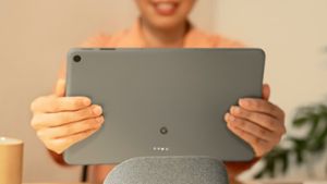 Eine Nutzerin nimmt das Google Pixel Tablet von seinem Ladedock. Foto: Google LLC