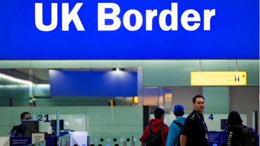 Grenzbeamte stehen am Flughafen Heathrow unter einem Schild mit der Aufschrift „UK Border“. Aktuell gibt es Probleme bei der Passkontrolle. Foto: dpa/Andrew Cowie