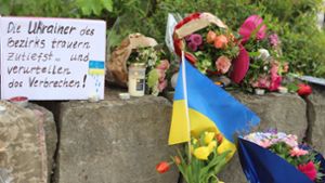 Am Gelände eines Einkaufszentrums, an dem zwei Männer aus der Ukraine getötet worden sind, wurden Blumen niedergelegt sowie eine kleine ukrainische Flagge aufgestellt. Foto: Constanze Wilz/dpa