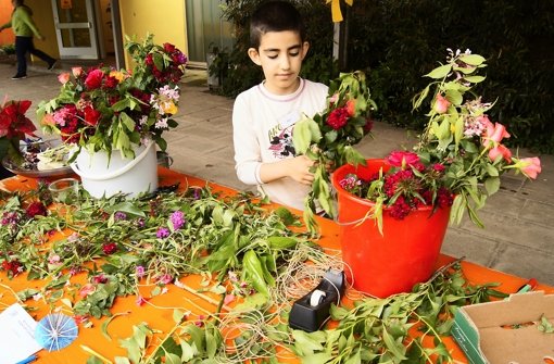 Der achtjährige Eren hat in der Spielstadt der Dietrich-Bonhoeffer-Schule Blumensträuße gebunden. Foto: Simone Bürkle