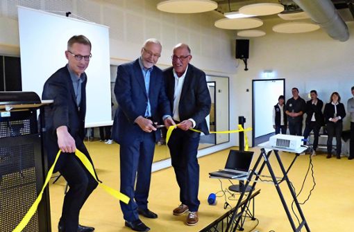 Johannes Berner (von links), Rainer Brechtken und Ulrich Lenk durchschneiden zur Eröffnung ein gelbes Band. Foto: Michael Käfer