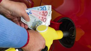 Eine junge Frau zahlt Betrügern Benzin und gibt ihnen Bargeld, wird aber misstrauisch. Foto: imago/McPHOTO/imago stock&people