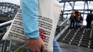 Ein Mann läuft mit einer Einkaufstüte des Münchner Buchhändlers Hugendubel eine Treppe rauf. Die Einkaufstüte von Hugendubel kommt international groß raus. Die „New York Times“ widmet dem „Leinensackerl“ in ihrer Online-Ausgabe eine eigene Geschichte. Foto: Sven Hoppe/dpa