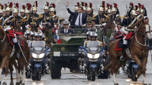 Große Inszenierung: Begleitet von Reitern der Ehrengarde und Polizeimotorrädern fährt der neuefranzösische Präsident Emmanuel Macron  in einem Militärfahrzeug  über die Champs-Elysees. Foto: AP