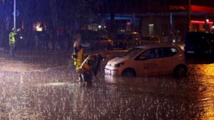 Feuerwehrleute sind auf einer überfluteten Straße in Aachen im Einsatz. Foto: dpa
