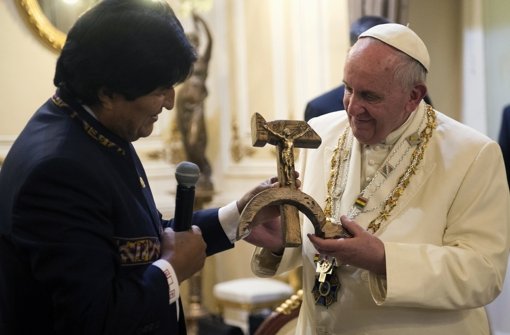 Da verschlägt es selbst dem stets spontanen Franziskus die Sprache, als ihm Boliviens Präsident Evo  Morales dieses ungewöhnliche Kreuz überreicht. Foto:  