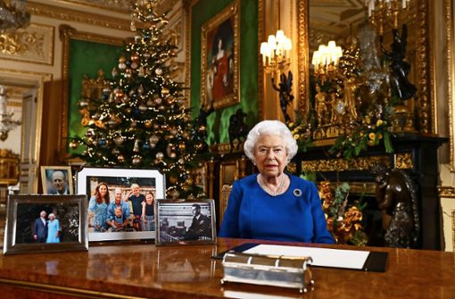 Die Queen bei ihrer Weihnachtsansprache. Im Hintergrund sieht man die Prunkuhr. Foto:  