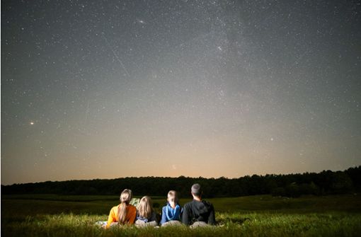Ein Familie schaut sich am Nachthimmel eine Perseiden-Schauer an. Foto: Imago/Pond5