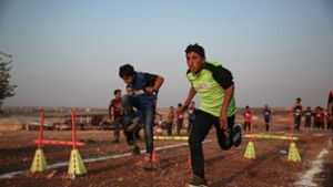 Wie bei den Olympischen Spielen trugen die Kinder die Farben ihres Lagers. Foto: dpa/Anas Alkharboutli