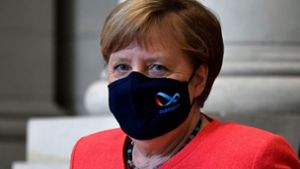 Angela Merkel trägt eine  schwarze Maske mit dem Logo der deutschen EU-Ratspräsidentschaft. Foto: AFP/JOHN MACDOUGALL