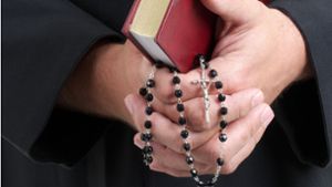 Ein katholischer Priester mit Bibel und Rosenkranz Foto: Fotolia