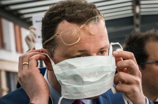 Gesundheitsminister Spahn kämpft mit seiner Gesichtsmaske. Foto: AFP/FRANK RUMPENHORST
