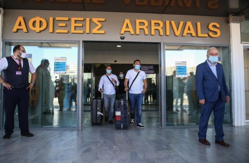 Touristen mit Mundschutz kommen am internationalen Flughafen der griechischen Insel Kreta an. Foto: dpa/Eurokinissi