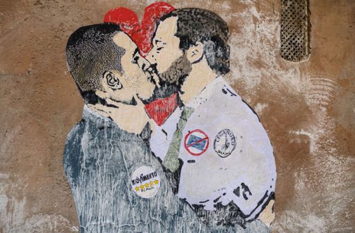 Straßenkunst an einer Hauswand in Rom: Luigi di Maio (l), Vorsitzender der Partei Fünf Sterne, und Matteo Salvini, Vorsitzender der Lega-Partei, knutschen sich an die Regierung. Mit einem hat das Liebenpaar aber nicht gerechnet: Silvio Berlusconi. Foto: AP