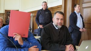 Einer der Angeklagten verdeckt sein Gesicht im Prozess. Foto: dpa/Miriam Steinruecken