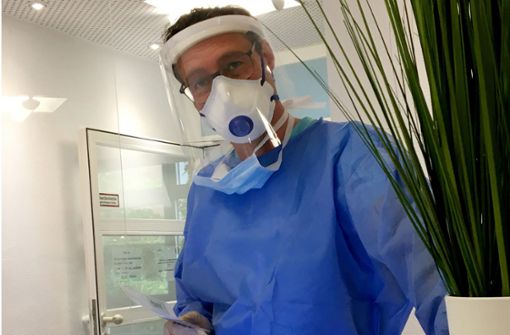 Der Stuttgarter Allgemeinarzt Cornelius Kübler bereitet sich im Schutzanzug auf einen Corona-Test vor. Foto: dpa/Kübler