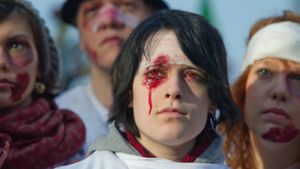 Jugendliche, die symbolisch Verletzungen an Augen und Kopf zeigen, demonstrieren gegen den gewaltsamen Polizeieinsatz am 30. September 2010. Foto: dpa