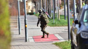 Ein Polizist des SEK trägt nach dem Einsatz in Reutlingen einen schusssicheren Schild zu einem Einsatzfahrzeug des Kommandos. Foto: Kevin Lermer/7aktuell.de