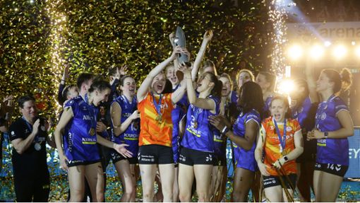 Da ist das Ding! Die Volleyballerinnen von Allianz MTV Stuttgart recken den Pokal im Lametta-Regen in die Höhe. Foto: Baumann/Hansjürgen Britsch