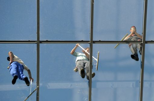 Fensterreiniger bei der Arbeit: Nicht immer geht es in der Branche sauber zu, bemängelt die  Gebäudereiniger-Gewerkschaft BAU. Foto: dpa/Arne Dedert