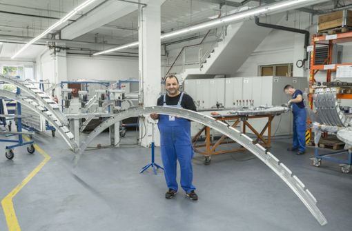 Ein Mitarbeiter hält im Werk Karlsruhe von Aircraft Philipp ein Blechteil für ein Flugzeugskelett. Foto: Aircraft Philipp Group/Wolfgang Stadler/ Fotografie
