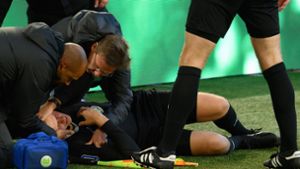 Schiedsrichter-Assistent Thorben Siewer liegt verletzt am Boden. Foto: dpa/Swen Pförtner