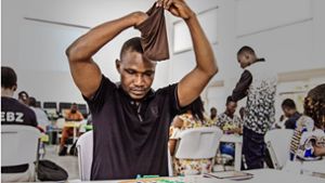 Wellington Jighere bei einer Partie Scrabble in Lagos. Aus dem Stoffbeutel über seinen Augen zieht er neue Buchstabensteine Foto: Putsch