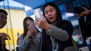 Deutschland hinkt technologisch hinterher: In Peking können iPhone-Besitzer bereits per Gesichtserkennung  bezahlen – der Dienst nennt sich „Smile to Pay“ („Lächle zum Bezahlen“). Diese Kundin tut sich mit dem Lächeln ganz offensichtlich schwer. Foto: AFP