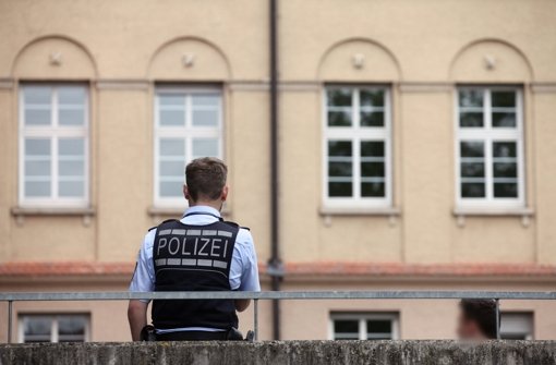 Ein Polizist steht im Mai 2015 in Nürtingen vor einer Schule, in der ein Mädchen in der Toilette überfallen und gefesselt wurde. Foto: dpa