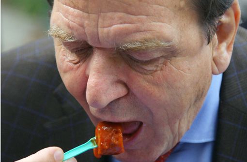 Der ehemalige Bundeskanzler Gerhard Schröder 2009 beim Essen einer Currywurst. Foto: dpa/Michael Hanschke