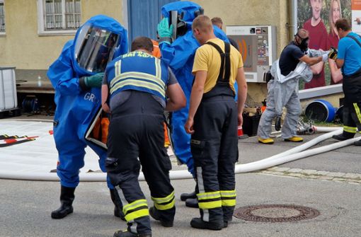 Einsatzkräfte in  Ortenburg tragen für den Einsatz nach einem Ammoniak-Austritt Schutzanzüge. Foto: zema-medien/dpa/Helmut Degenhart