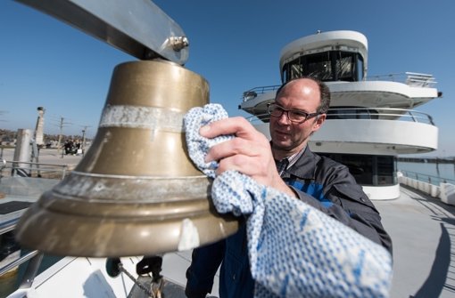 Schiffsführer Christoph Rimmele poliert im Hafen von Konstanz die Schiffsglocke des Ausflugsschiffes „Überlingen“. Foto: dpa