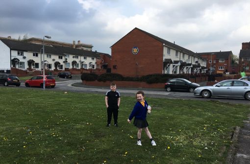 In Lower Shankill spielen Kinder vor den Wappen paramilitärischer Organisationen. Foto: Sabine Fischer