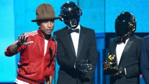 Bei den Grammy Awards 2014 in Los Angeles bekommt Pharrell Williams (links) mit Daft Punk (Thomas Bangalter, Mitte, und Guy-Manuel de Homem-Christo) einen Preis für „Get Lucky“. Foto: AFP/Kevork Djansezian