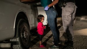 Das Pressefoto des Jahres zeigt das Flüchtlingsmädchen Yanela Sanchez, weinend an der US-mexikanischen Grenze. Ihre Mutter, die Honduranerin Sandra Sanchez steht vor ihr und wird von einem Grenzschutzbeamten abgetastet. Foto: John Moore/Getty Images/dpa